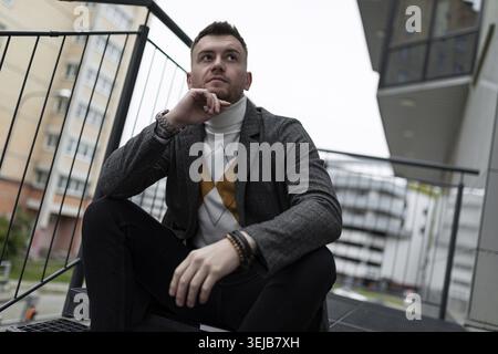 Straßenporträt eines durchdacht stilvollen jungen Mannes Stockfoto