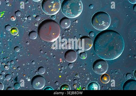 Minimaler abstrakter Makrohintergrund mit Wasser- und Ölblasen auf einer weichen grauen Oberfläche mit subtilen bunten Reflexen. Saubere, moderne Textur ideal Stockfoto