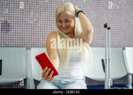 Frau, die im Flughafen Selfie-Video mit Smartphone macht Stockfoto