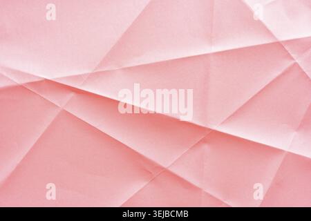 Abstrakte geometrische Faltpapierstruktur in Pastellrosa mit weichen Schatten und Faltenmustern Stockfoto