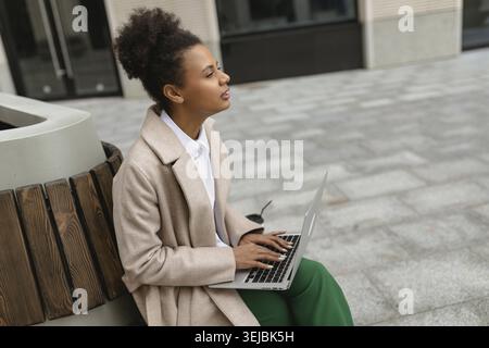 afroamerikanerin Cybersicherheitsspezialistin, die an einem Laptop neben dem Business Center arbeitet Stockfoto