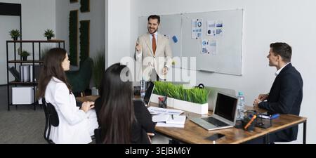 Brainstorming-Meeting in einem Team von Geschäftskollegen, die am Tisch sitzen und das Konzept der Geschäftsentwicklung diskutieren Stockfoto