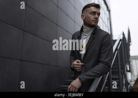 Brutaler, stylischer junger Mann im Herbstmantel draußen Stockfoto