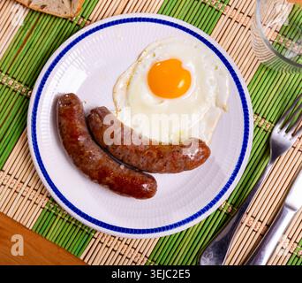 Frühstück mit sonnigen Eiern und gegrillten Butifarra Würstchen Stockfoto