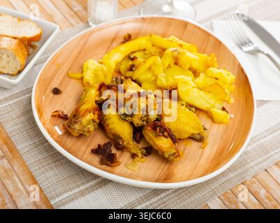 Knoblauch-Hühnerflügel (Pollo al Ajillo) mit Kartoffeln. Stockfoto
