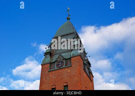 Göteborg, Schweden-24. November 2025: Roter Backsteinglockenturm der Masthugget-Kirche steht vor einem klaren blauen Himmel Stockfoto
