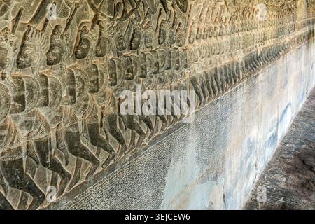 Reihen von geschnitzten Mahabharata-Kriegern ziehen über das Basrelief der Schlacht von Kurukshetra an der Westgaleriewand von Angkor Wat, Kambodscha Stockfoto