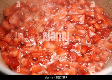 Erdbeeren, die tagsüber in einem Topf auf dem Herd gekocht werden Stockfoto