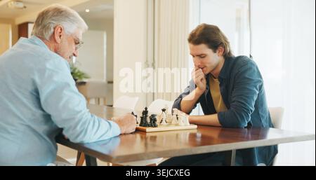 Senior Vater, Sohn und Schach zu Hause mit Strategie, Lösung oder Problemlösung im Wettbewerb für das Wochenende. Familie, Brettspiel und die Bindung an die Konkurrenz Stockfoto