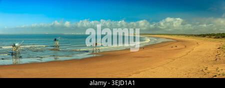Aveiro, Portugal - 19.08.2023: Küstenlandschaft mit traditionellen Netzfischern in flachen Atlantikwellen an einem weiten sonnigen Strand Stockfoto