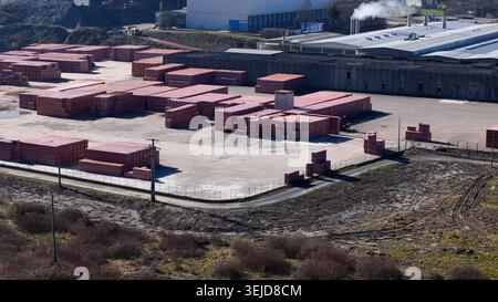 Aus der Vogelperspektive eines weitläufigen Industriekomplexes mit zahlreichen roten Ziegelsteinen und einem Fabrikgebäude mit Rauch aus dem Kamin Stockfoto