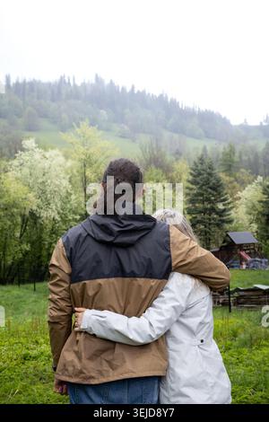 Rückblick auf Paare, die sich während eines romantischen Kurzurlaubs in die Berglandschaft umziehen. Zweisamkeit, emotionale Verbundenheit und Outdoor-Lifestyle-Konzept Stockfoto