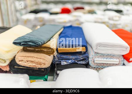 Verschiedene farbenfrohe Stoffrollen und Textilmaterialien werden im Einzelhandel ausgestellt Stockfoto
