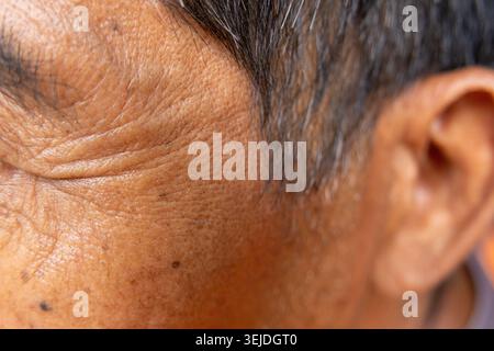 Nahaufnahme Makrodetail, das das Gesicht älterer Menschen mit tiefen Falten und alternder Hautstruktur zeigt, mit ruhiger Ruhe um den geschlossenen Augenbügel und Stockfoto