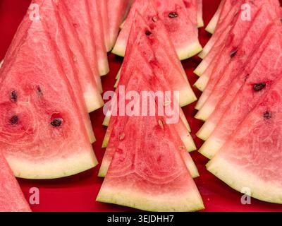 Leuchtend rote Wassermelonenscheiben mit Samen aus Nahaufnahme, erfrischendes Sommerfrucht-Konzept Stockfoto