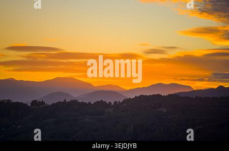 Schichten von Bergen, die bei Sonnenuntergang Silhouetten Stockfoto
