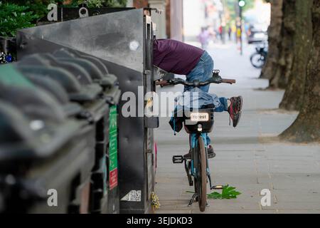 London, England, Großbritannien. Mai 2026. In Westminster, London, sucht ein Mann einen Kleiderbehälter, während er auf einem Fahrrad balanciert, unter anhaltendem Druck auf die Lebenshaltungskosten und steigenden Sorgen um Obdachlosigkeit in der Hauptstadt. (Kreditbild: © Thomas Krych/ZUMA Press Wire) NUR REDAKTIONELLE VERWENDUNG! Nicht für kommerzielle ZWECKE! Stockfoto