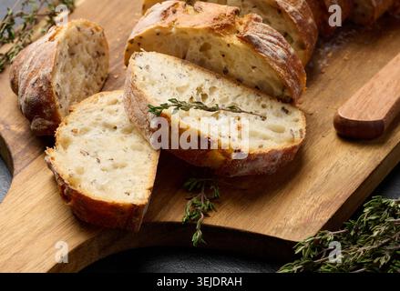 Geschnittene ​​baguette mit Flachs und Gewürzen auf einem hölzernen Schneidebrett Stockfoto
