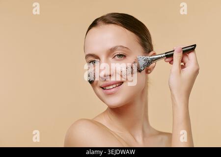 Porträt einer erwachsenen Frau, die Gesichtsmaske für Hautpflege-Marketing anwendet Stockfoto