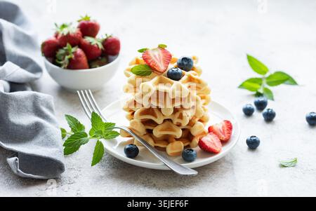 Frisch gebackene Waffeln mit Erdbeeren und Heidelbeeren Stockfoto