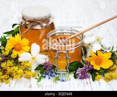 Honig und wilde Blumen auf hölzernem Hintergrund Stockfoto