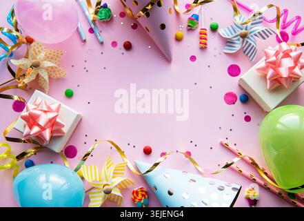 Clipboard und farbenfrohe Dekorationen auf pinkfarbenem Pastellhintergrund. Flache Lage, Draufsicht. Geburtstagshintergrund, Urlaubskonzept. Stockfoto