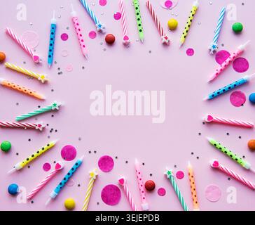 Fröhliches Geburtstagskonzept, Konfetti und bunte Kerzen auf pinkfarbenem Hintergrund, flacher Lay, Draufsicht Stockfoto