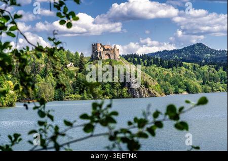 Historische Ruinen der Burg Czorsztyn auf einem Hügel mit Blick auf den blauen See, umgeben von grünen Wäldern und Bergen. Mittelalterliche Festungslandschaft mit t Stockfoto