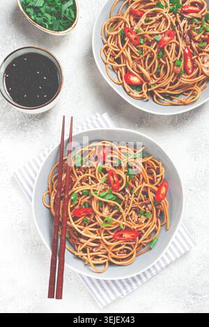 Udon-Nudeln, mit Shimeji-Pilzen, Gemüse, in Sauce, mit Sesamsamen, grüne Zwiebeln, asiatische vegetarische Gerichte, horizontal, Stockfoto