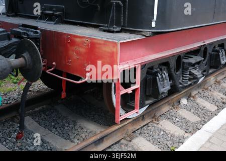 Rostige Zugräder ruhen auf hölzernen Gleisen an einem charmanten alten Bahnhof. Stockfoto