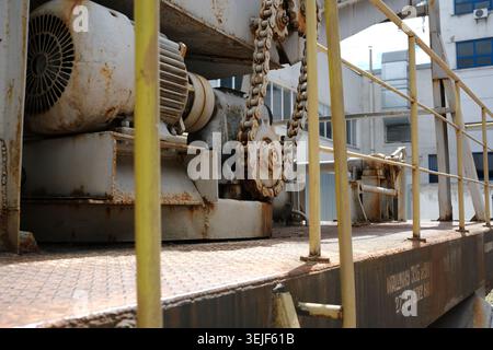 Alte Maschinen stehen auf einer stark frequentierten Baustelle im Vordergrund und spiegeln Verschleiß und Verwendung wider. Stockfoto