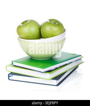 Grüne Äpfel in Obstschale und Büchern Stockfoto