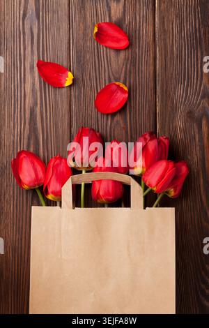 Rote Tulpenstrauß im Beutel über Holz Stockfoto