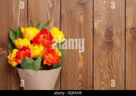 Bunte Tulpen über Holztisch Stockfoto