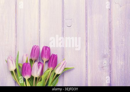 Lila Tulpenstrauß über Holztisch Stockfoto