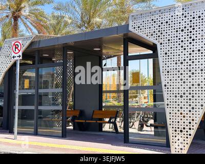 Ein eleganter, moderner Gartenraum aus Glas mit schwarzem Metallrahmen, an einer Ziegelwand befestigt, mit großen Fenstern und Tageslicht. Stockfoto