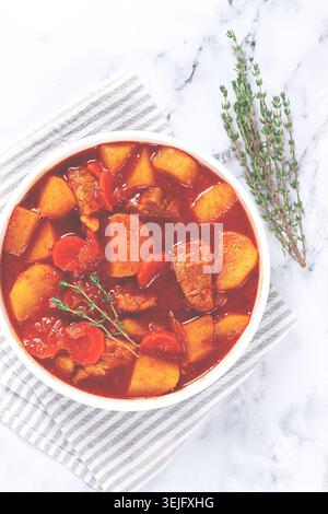 Fleischgulasch mit Kartoffeln und Karotten, Paprika, in einem Topf, Blick von oben, traditionelle ungarische Suppe, hausgemacht, keine Leute, Stockfoto