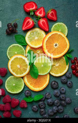 Mischung aus Früchten und Beeren, Set, Sortiment, geschnittene Zitrusfrüchte, Himbeeren, Heidelbeeren, Minzblätter, Erdbeeren, rotes curran Stockfoto