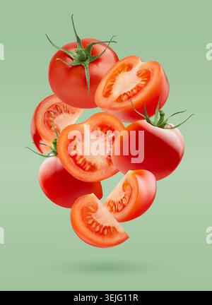 Reife Kirschtomaten mit grünen Stielen, ganz, Viertel, Stück fliegen wie Fluss wie Kunstkomposition auf grünem Hintergrund. Sommer gesund Stockfoto