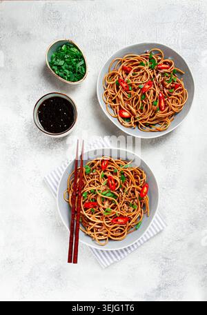 Udon-Nudeln, mit Shimeji-Pilzen, Gemüse, in Sauce, mit Sesamsamen, grüne Zwiebeln, asiatische vegetarische Gerichte, horizontal, Stockfoto