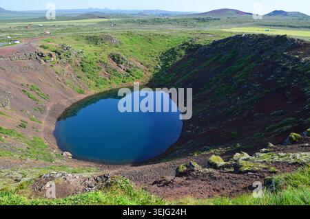 Panoramablick auf das tiefblaue Wasser im Inneren des vulkanischen Kratersees von Kerið im Süden Islands. Stockfoto