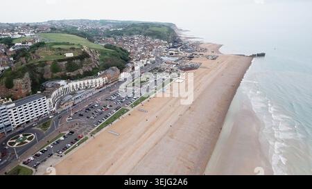 4K-Drohnenansicht von Hastings, England. Panoramablick auf die Küstenlandschaft mit Kieselstrand, Strandpromenade, Stadtarchitektur und Klippen. Stockfoto