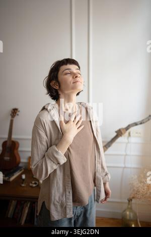 Junge Frau, die Stressabbau übt, Atemübungen zur Beruhigung macht, Hand auf Brust hält. Stockfoto