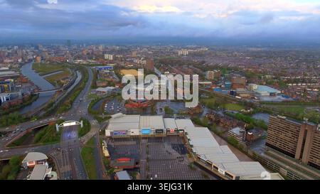 4K-Drohnenfoto von Manchester, England. Moody Cityscape Panorama mit einem Einzelhandelspark, städtischer Infrastruktur, Fluss und Skyline der Stadt. Stockfoto