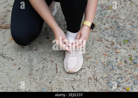 Aktive gesunde asiatische Frau binden Laufschuhe, Jogging Läufer Gesundheit und Wohlbefinden Stockfoto