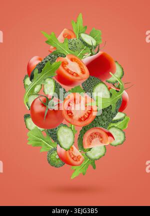 Zutaten für Bio-Gemüsesalat - rote Tomaten, grüne Gurken, gemischtes Grün, Levitation als Fluss in der Kunstkomposition auf Rosa Stockfoto