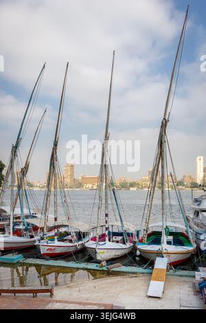 Kairo, Ägypten, 25.07.21. Ali Baba Hafen auf dem Nil in Kairo mit traditionellen Feluken-Ausflugsbooten und Gizeh Stadtbild im Hintergrund. Stockfoto