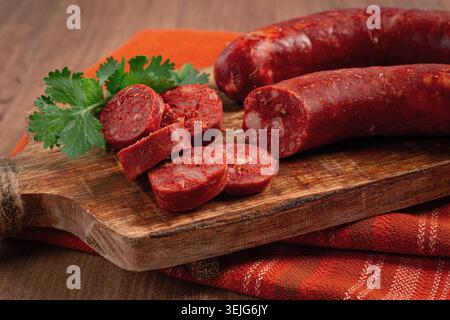 Scharfe Chorizo-Wurst, auf einem Schneidebrett, auf einem Holztisch. Stockfoto