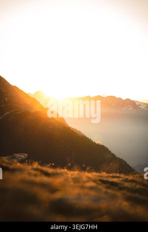Goldener Sonnenaufgang über den Alpen vom Tscharser Wetterkreuz aus gesehen, Bergkämme im warmen Morgenlicht baden. Stockfoto