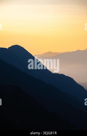 Mehrschichtige Bergsilhouetten bei Sonnenaufgang über dem Inntal bei Innsbruck, Österreich. Stockfoto